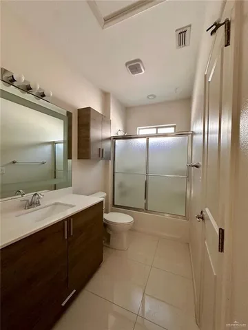 a bathroom with a double vanity sink toilet and shower