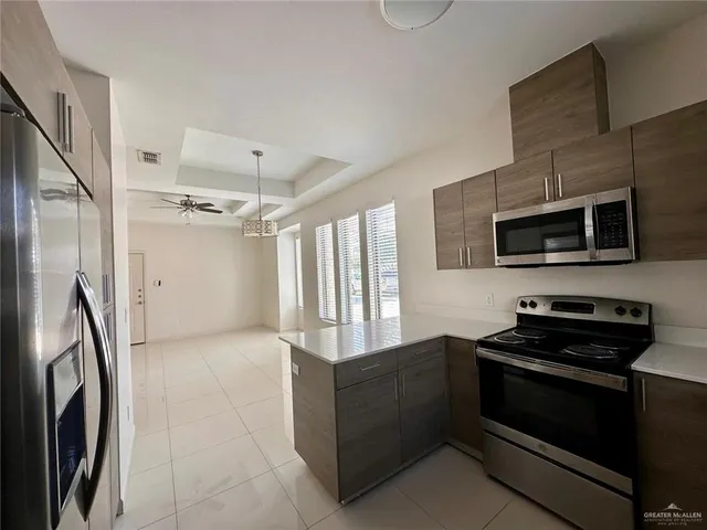 a kitchen with stainless steel appliances granite countertop a refrigerator and a stove top oven