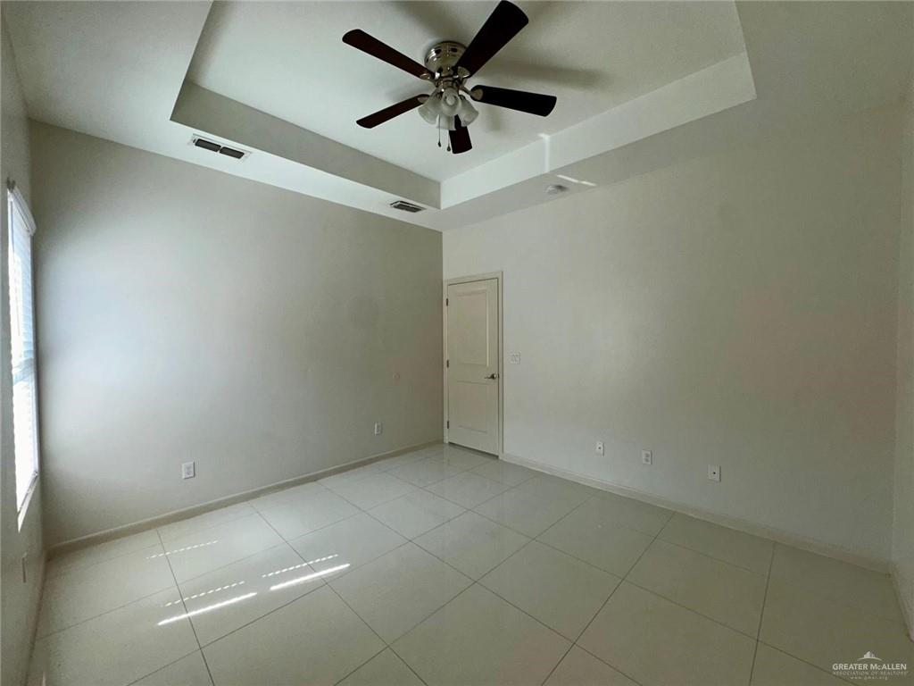 5700 Nightingale Avenue, Unit 1 Mission, TX 78573 - Photo 10 of 21 an empty room with a ceiling fan and carpet