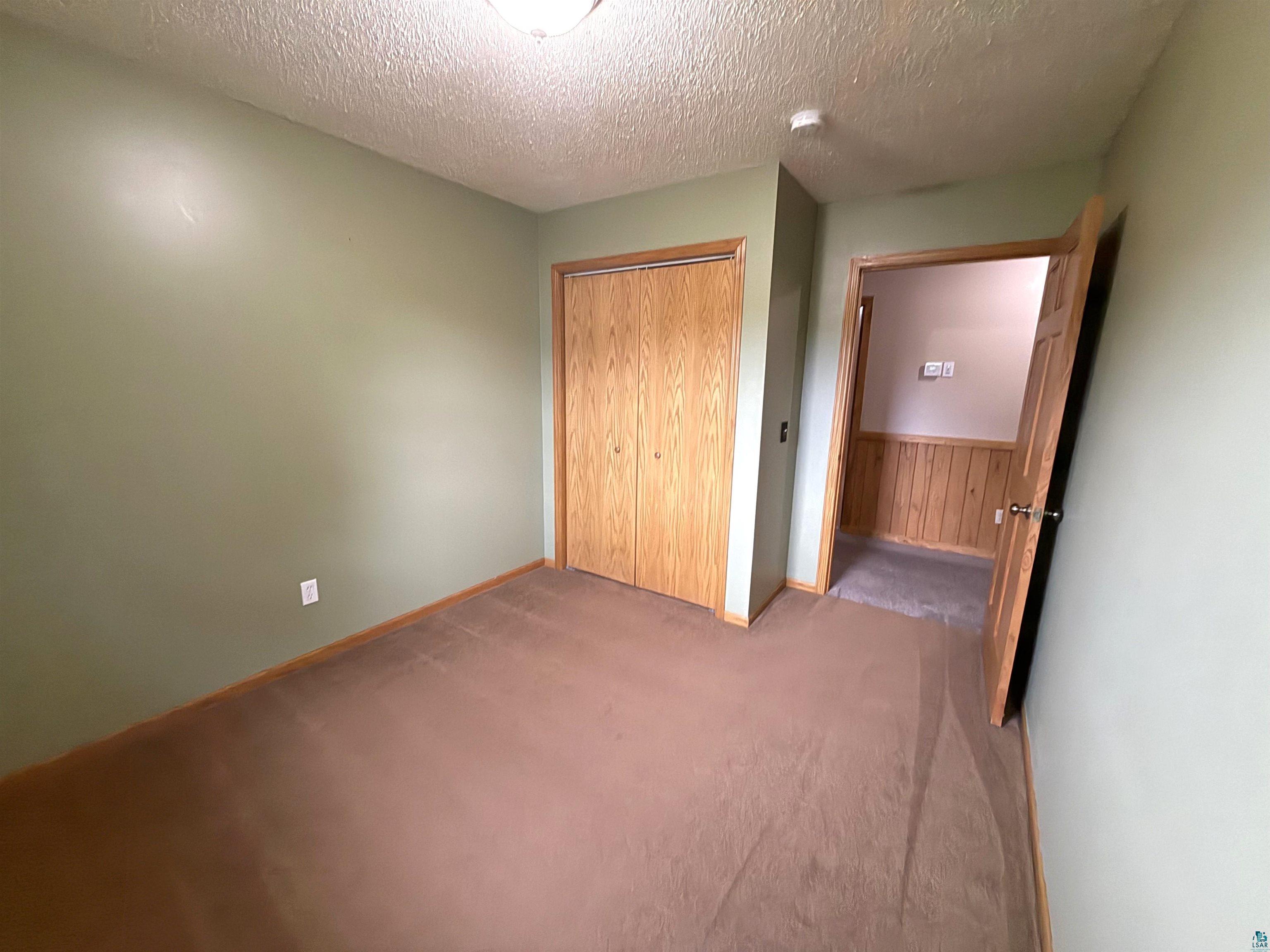 5080 Tower Road Moose Lake, MN 55767 - Photo 25 of 49 Wall-to-wall carpeting with light green painted walls
