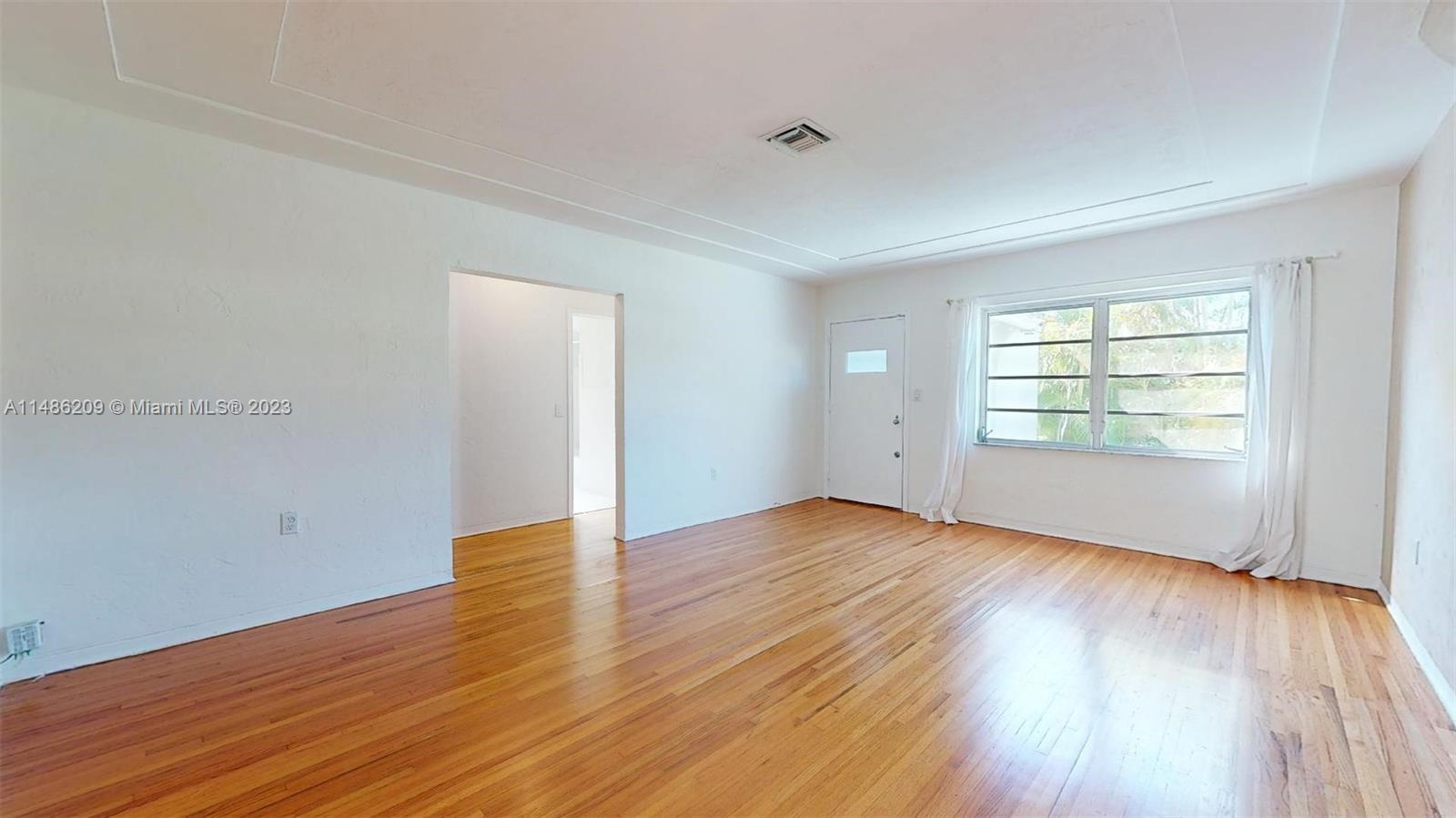 Normandy Beach Surfside, FL 33154 - Photo 6 of 22 an empty room with wooden floor and windows