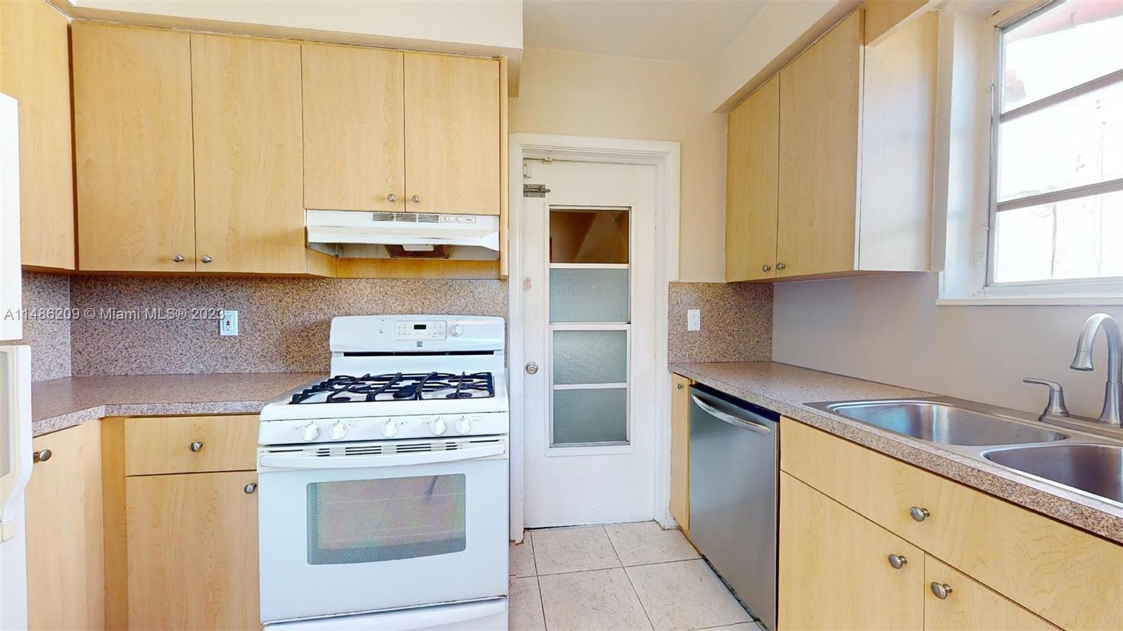 Normandy Beach Surfside, FL 33154 - Photo 10 of 22 a kitchen with a stove a sink and a refrigerator