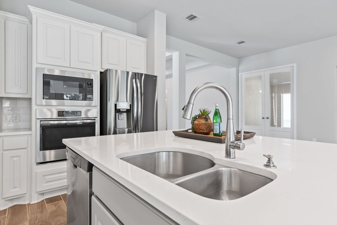 3604 Mercer Road Georgetown, TX 78628 - Photo 13 of 39 a kitchen with a sink a counter space and stainless steel appliances