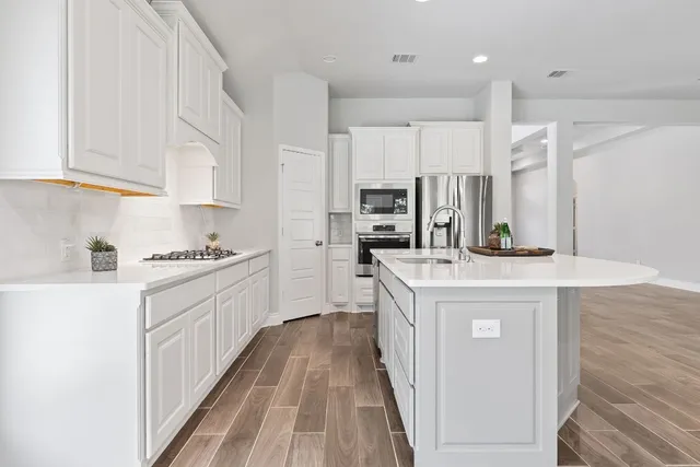 a kitchen with kitchen island granite countertop a sink stove and refrigerator