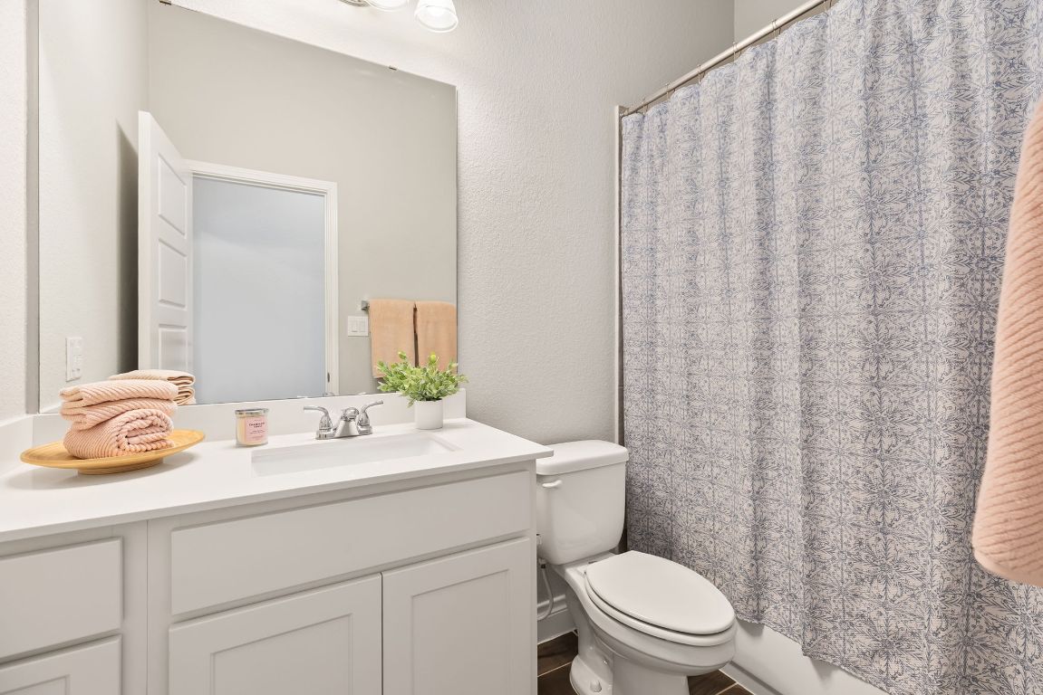 3604 Mercer Road Georgetown, TX 78628 - Photo 31 of 39 a bathroom with a sink a toilet and shower curtain