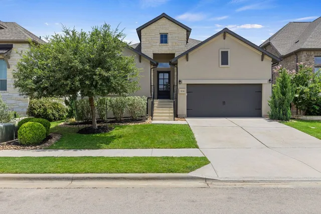 a front view of a house with a garden and plants
