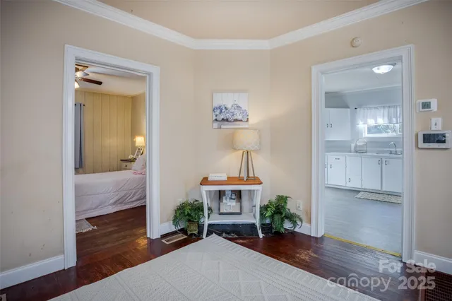 a view of a hallway with wooden floor and a bathroom