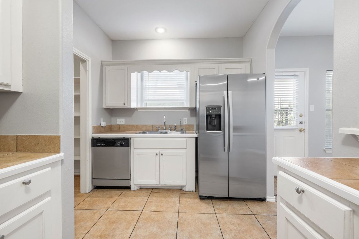 2906 Pearl Street, Unit C Austin, TX 78705 - Photo 9 of 28 a kitchen with a refrigerator sink and cabinets
