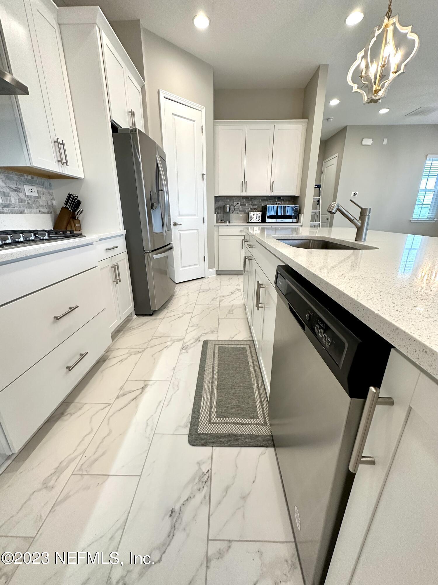 481 Marquesa Circle St. Johns, FL 32259 - Photo 12 of 53 a kitchen with a sink stainless steel appliances cabinets and a window