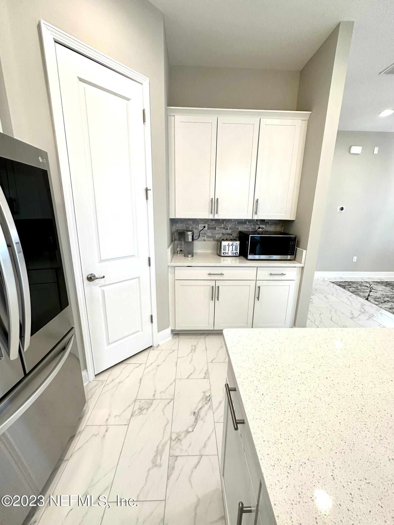 481 Marquesa Circle St. Johns, FL 32259 - Photo 13 of 53 a large white kitchen with sink a microwave and cabinets