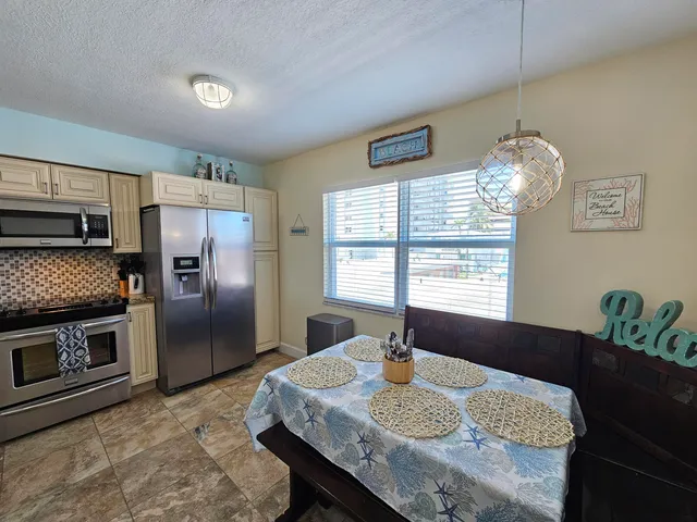 a kitchen with granite countertop kitchen island stainless steel appliances a sink stove and refrigerator