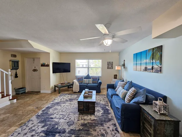 a living room with furniture a ceiling fan and a window