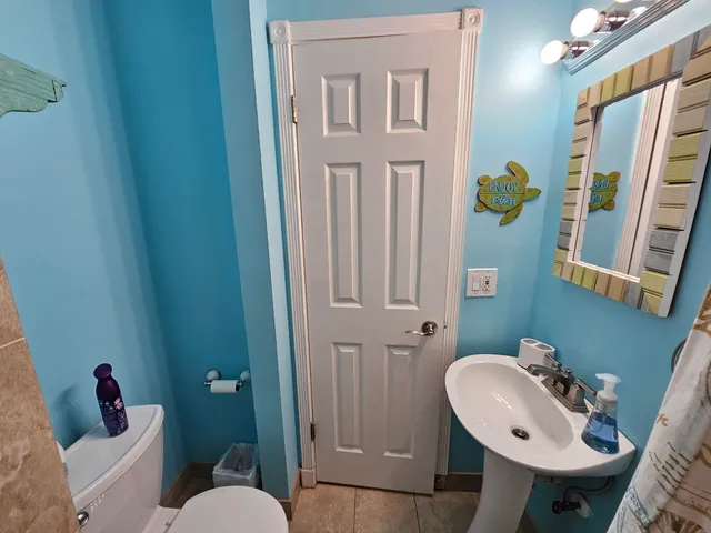 a bathroom with a sink a toilet and mirror