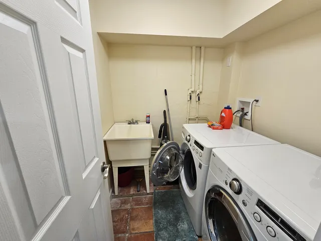 a utility room with dryer washer and sink