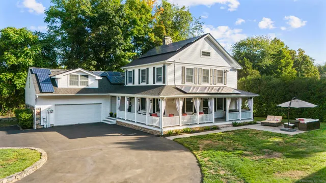 a front view of a house with a garden and lake view