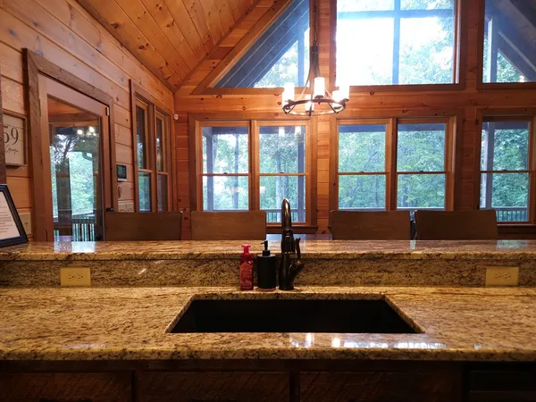 a view of a kitchen with granite countertop a sink and a stove