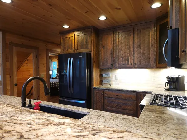 a kitchen with granite countertop wooden cabinets and a sink