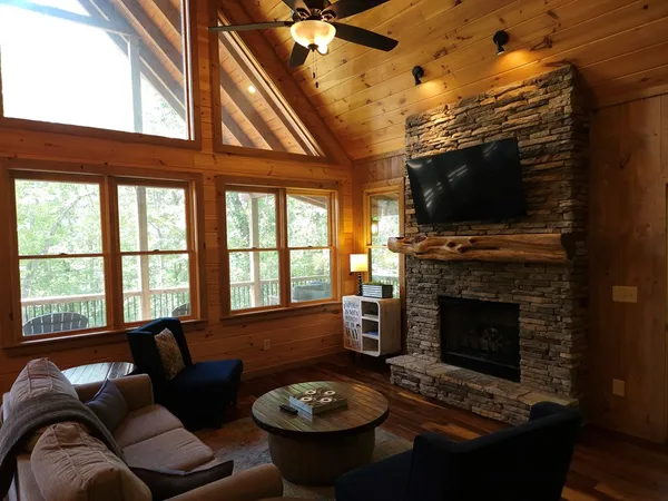 a living room with furniture a fireplace and a flat screen tv