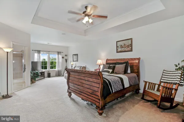 a spacious bedroom with a bed and a chandelier