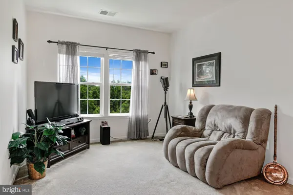 a living room with furniture a flat screen tv and a large window