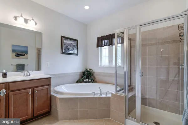 a bathroom with a tub a sink and mirror