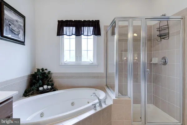 a bathroom with a tub shower and window