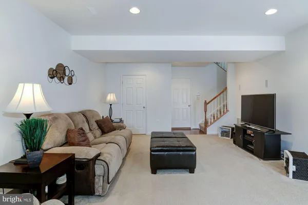 a living room with furniture a flat screen tv and a couch