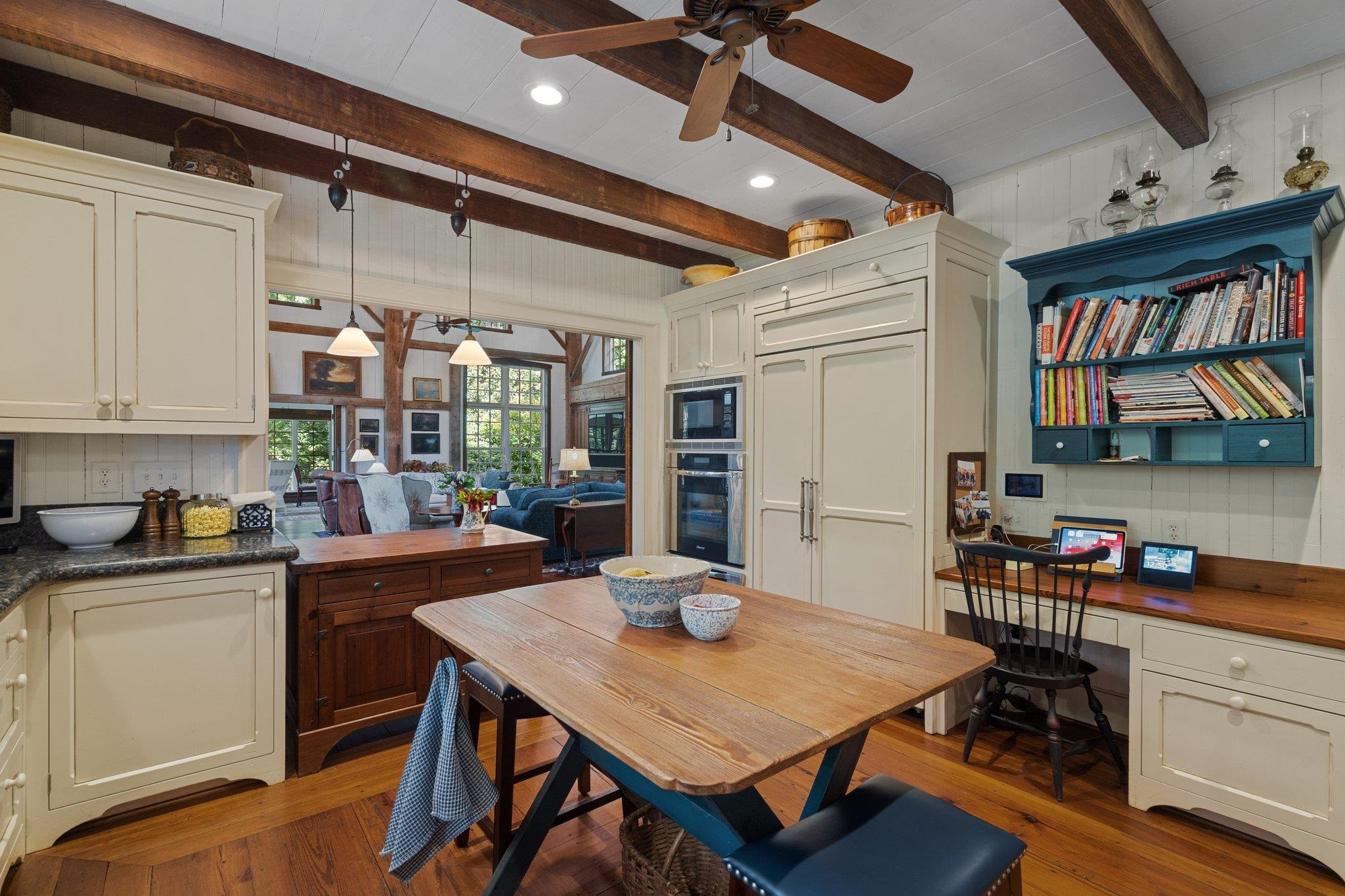 4900 West Cornwallis Road Durham, NC 27705 - Photo 39 of 100 a kitchen with stainless steel appliances granite countertop a stove a refrigerator a dining table and chairs with wooden floor