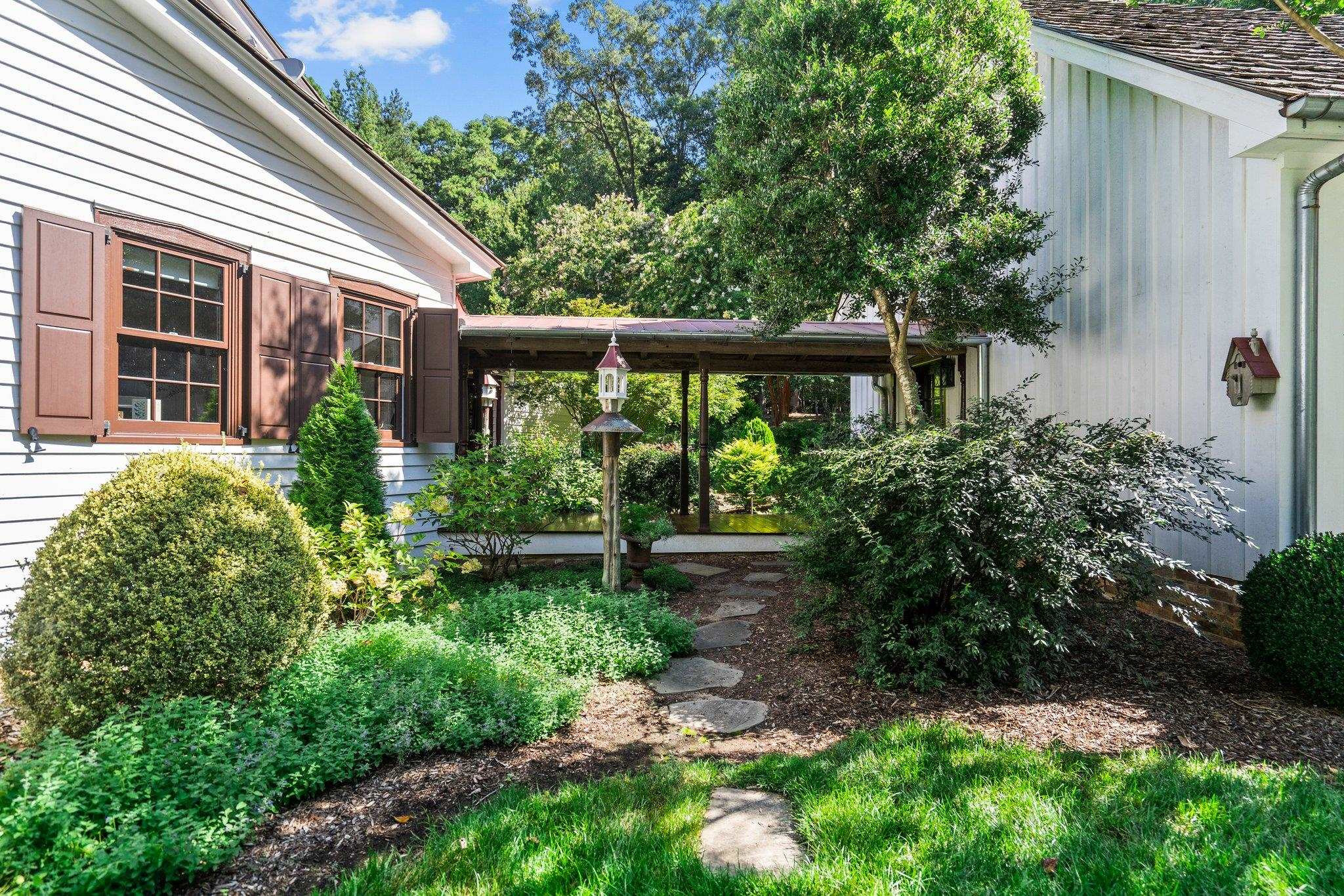 4900 West Cornwallis Road Durham, NC 27705 - Photo 49 of 100 a view of a house with a yard and plants