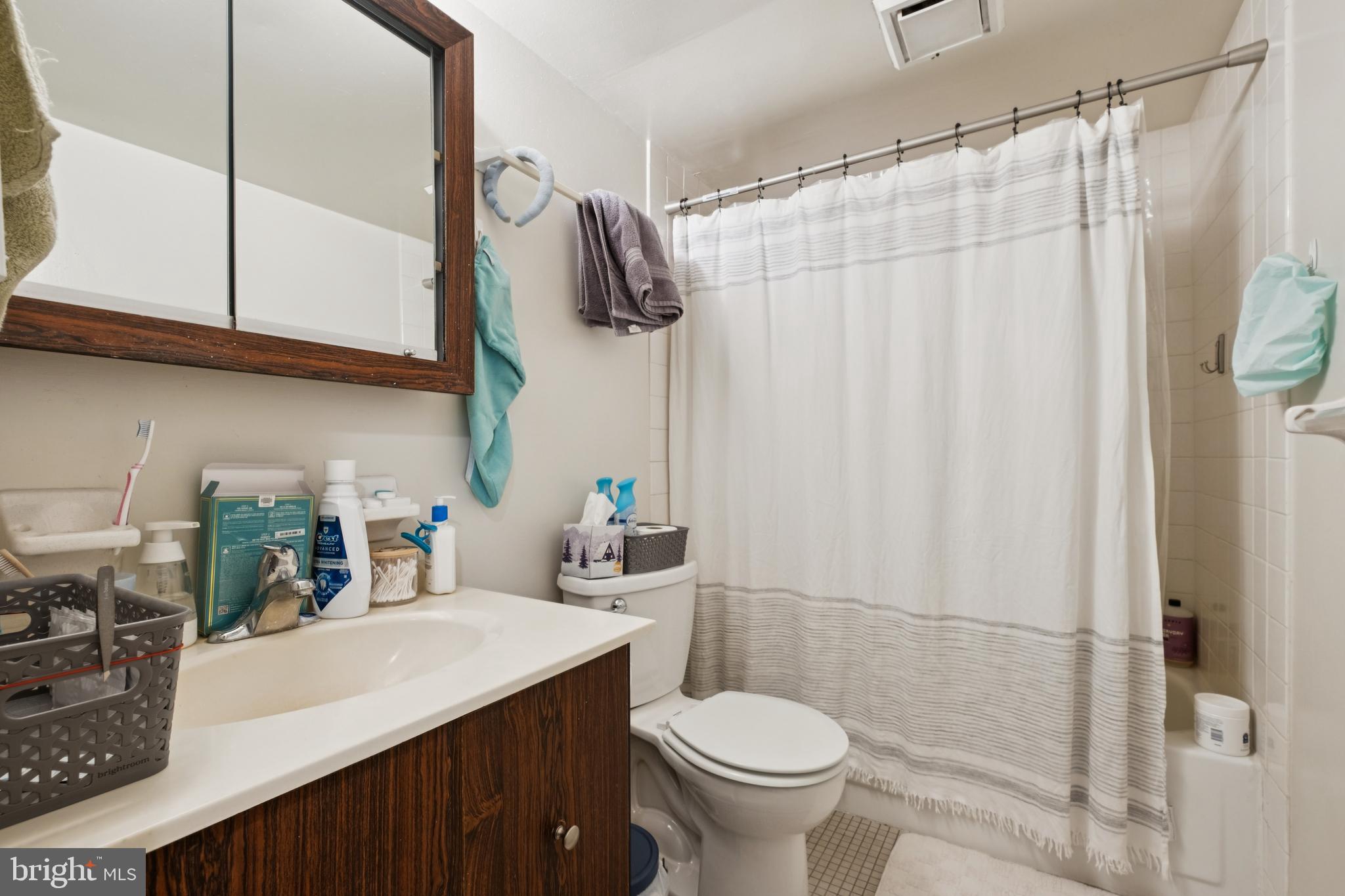 1420 Locust Street, Unit 31H Philadelphia, PA 19102 - Photo 5 of 15 a bathroom with a sink a toilet and shower curtain