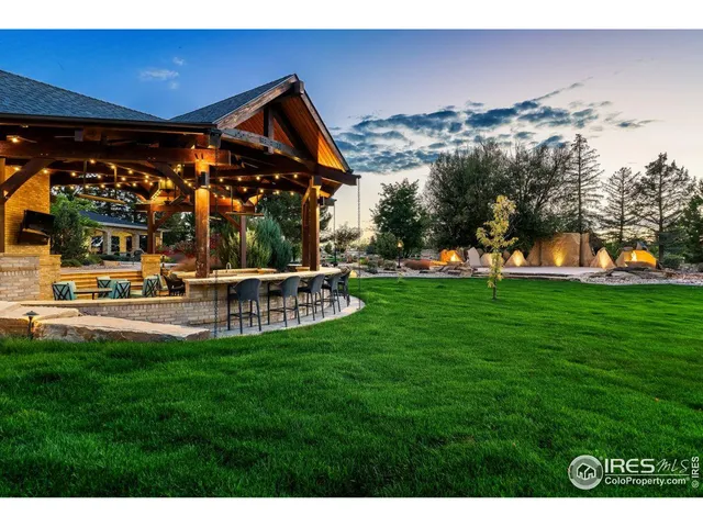 a view of a house with backyard water fountain and sitting area