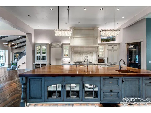 a kitchen with stainless steel appliances granite countertop a kitchen island a stove a sink a dining table and chairs