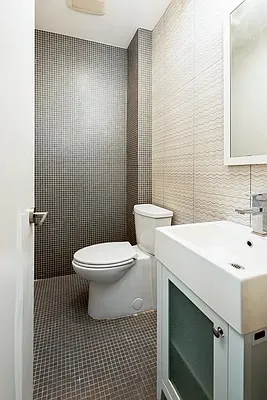 a bathroom with a toilet a sink and mirror