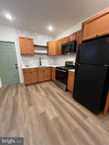 a kitchen with stainless steel appliances granite countertop a stove a refrigerator a sink and a microwave