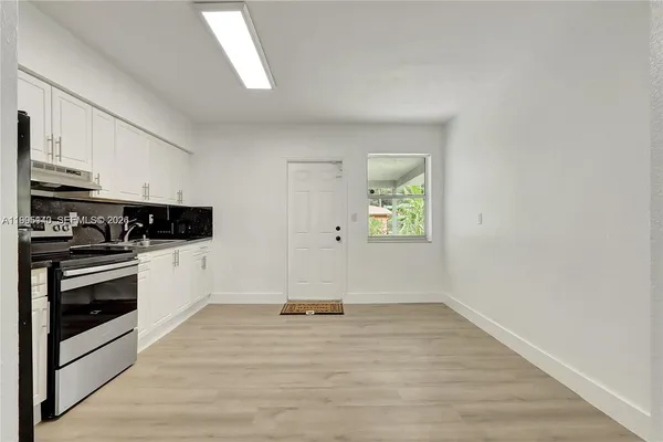 a view of kitchen with wooden floor electronic appliances and window