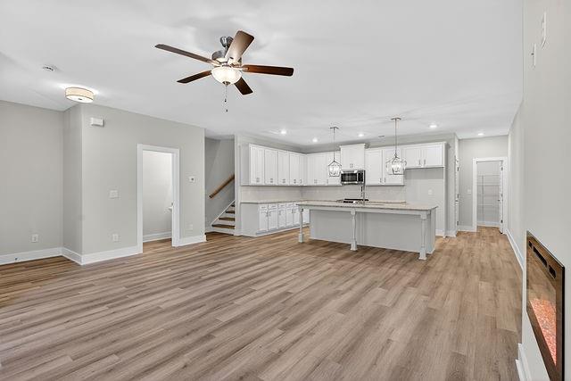 2562 Harbor Ridge Pass Gainesville, GA 30507 - Photo 5 of 27 a view of an empty room with wooden floor and a kitchen