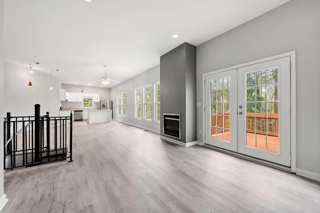 an empty room with wooden floor and windows