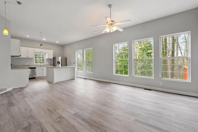 a view of a kitchen with a stove cabinets potted plants and wooden floor