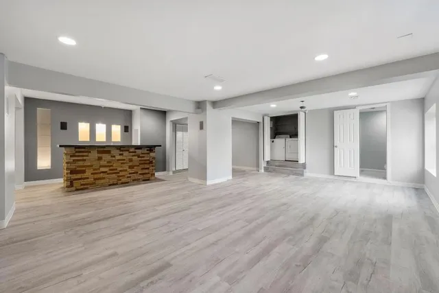 a view of an empty room with wooden floor and entryway