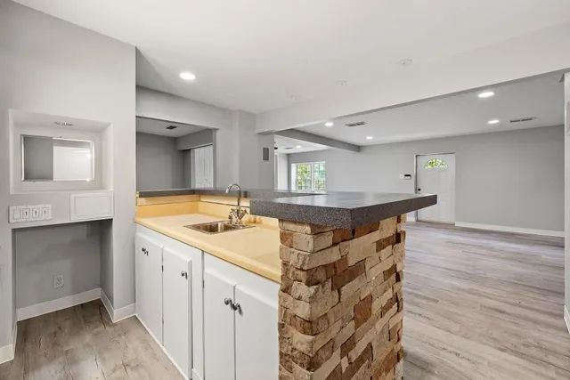 a kitchen with a stove and a hallway