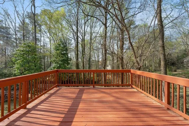 a view of deck with trees and wooden fence