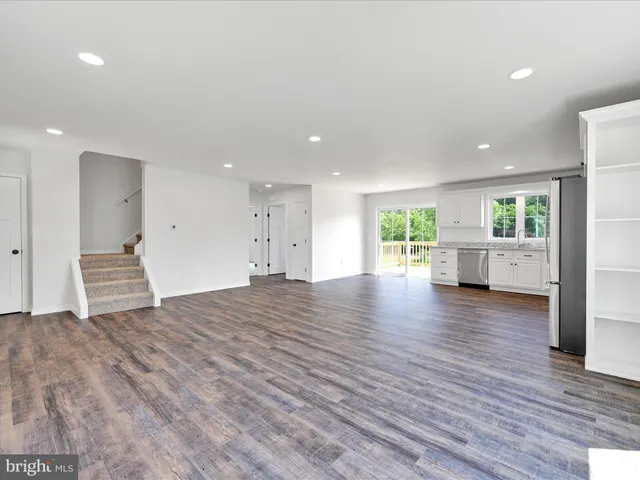 a view of empty room with wooden floor and windows