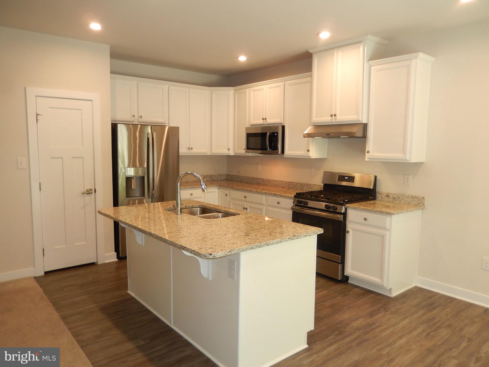 36884 Red Cedar Loop Ocean View, DE 19970 - Photo 11 of 50 a kitchen with stainless steel appliances granite countertop a sink stove and refrigerator