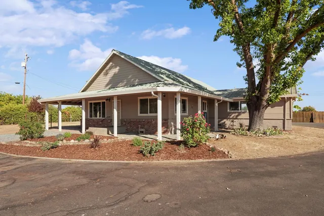 a front view of a house with a garden and patio