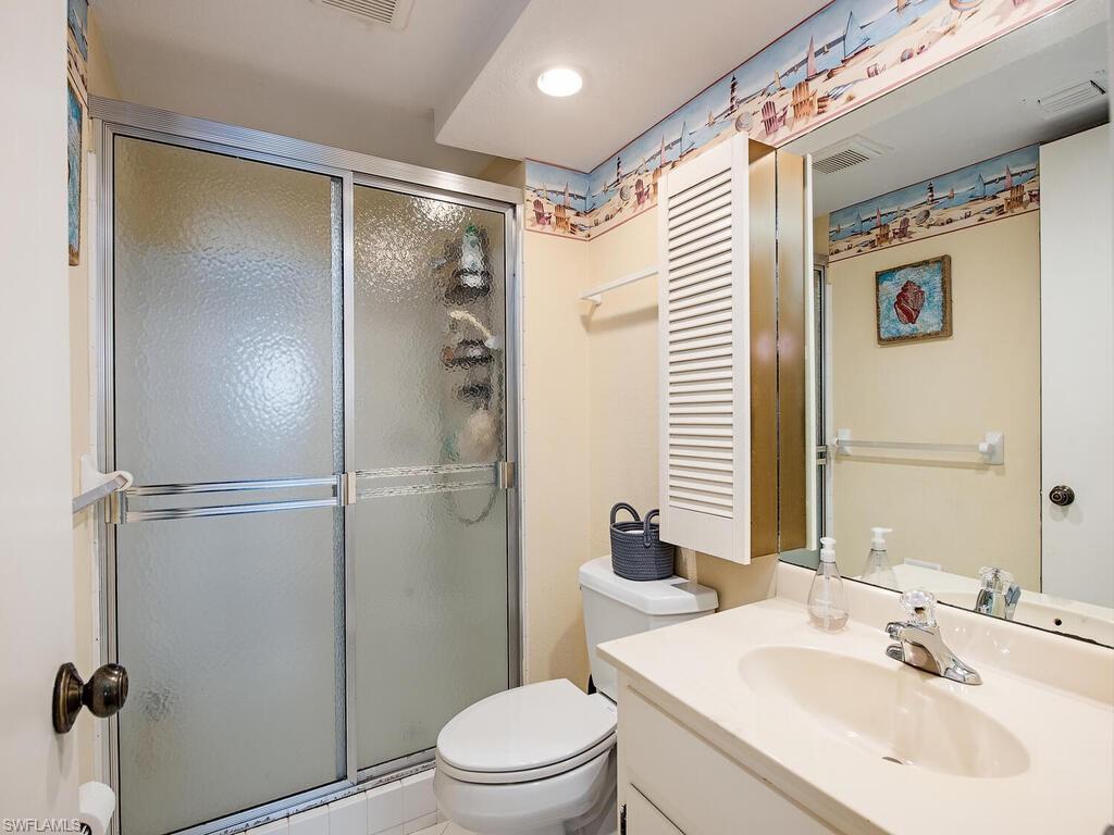 53 High Point Circle West, Unit 101 Naples, FL 34103 - Photo 11 of 18 a bathroom with a sink toilet and shower