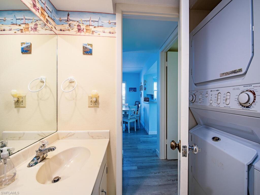 53 High Point Circle West, Unit 101 Naples, FL 34103 - Photo 12 of 18 a bathroom with a sink a mirror and a shower