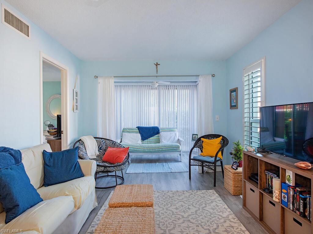 53 High Point Circle West, Unit 101 Naples, FL 34103 - Photo 2 of 18 a living room with furniture a rug and a flat screen tv