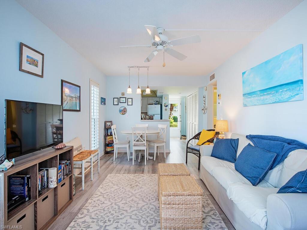 53 High Point Circle West, Unit 101 Naples, FL 34103 - Photo 3 of 18 a living room with furniture and a flat screen tv