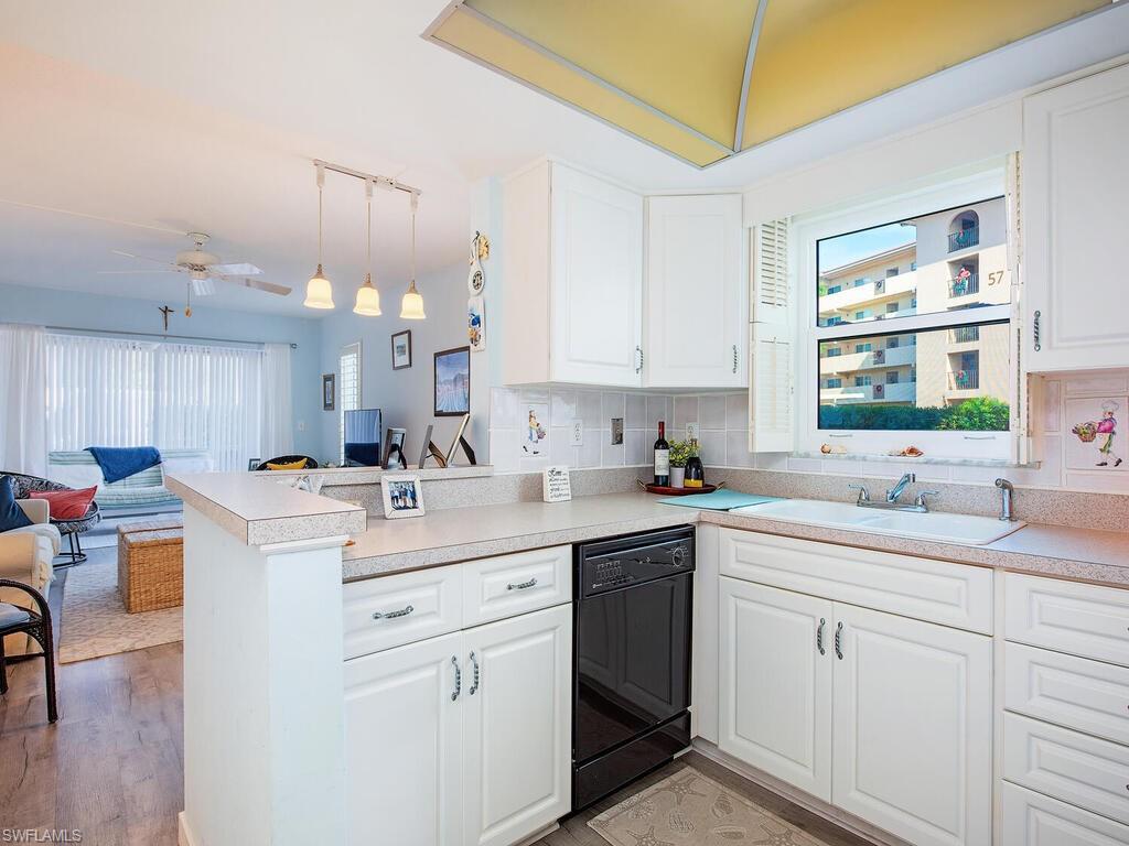 53 High Point Circle West, Unit 101 Naples, FL 34103 - Photo 4 of 18 a kitchen with a sink a window and cabinets