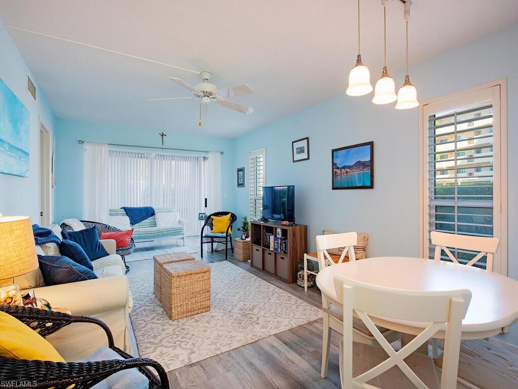 53 High Point Circle West, Unit 101 Naples, FL 34103 - Photo 7 of 18 a living room with furniture kitchen view and a chandelier